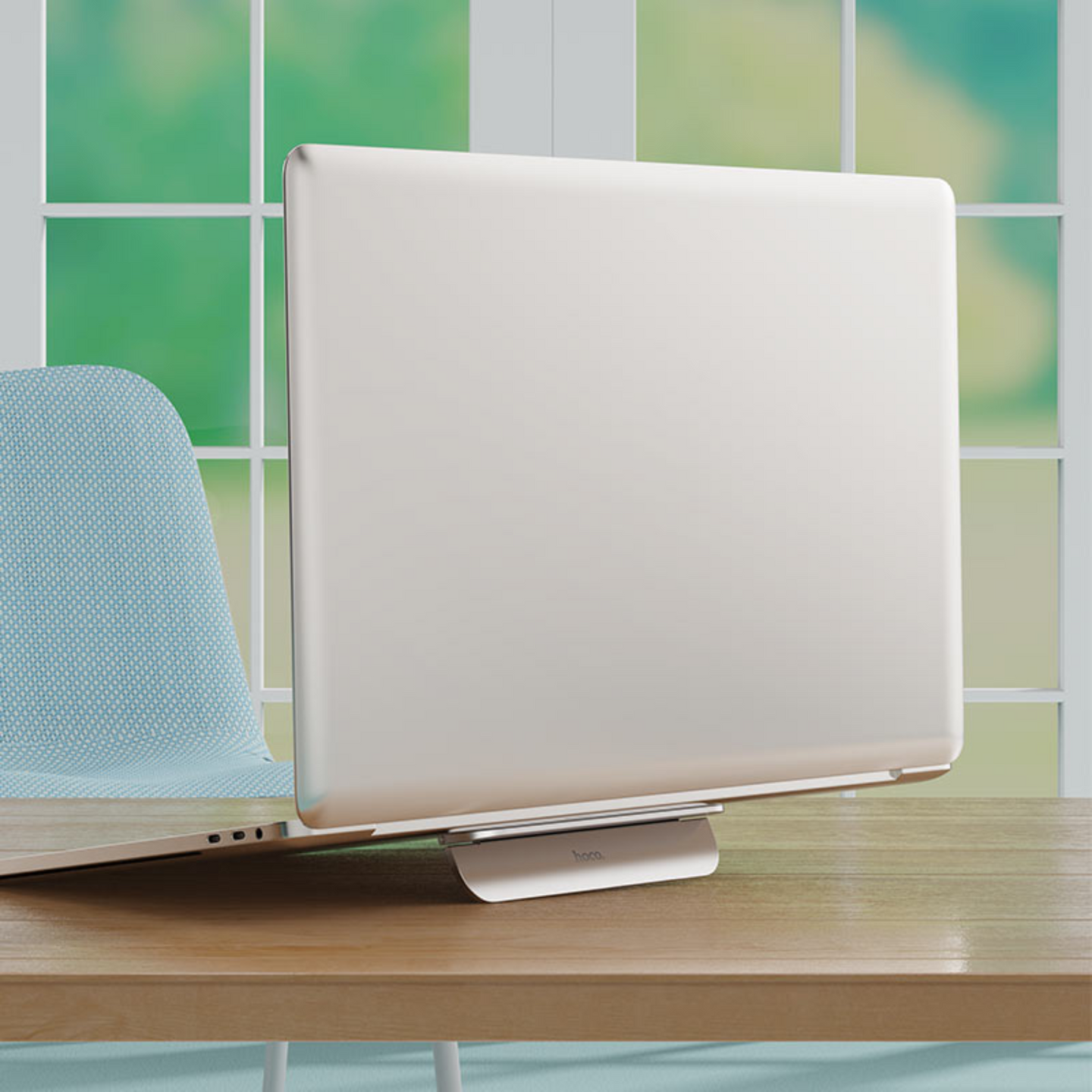 An image showing Metal Foldable Laptop Stand (PH40) being attached to a laptop and is in use on a working desk
