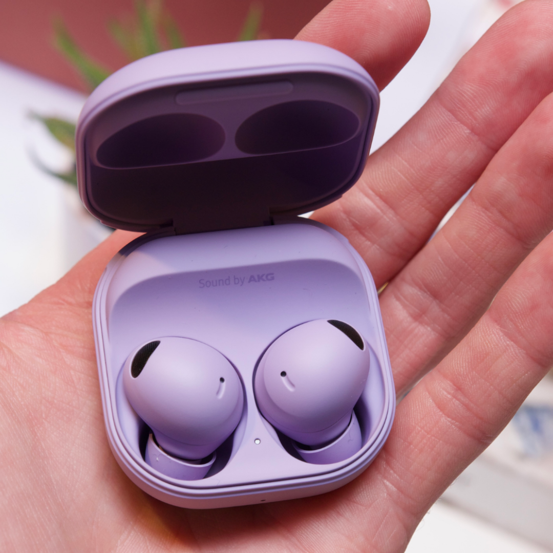 A photo showing a pair of white wireless earbuds in an open charging case. The earbuds are partially visible inside the case. 