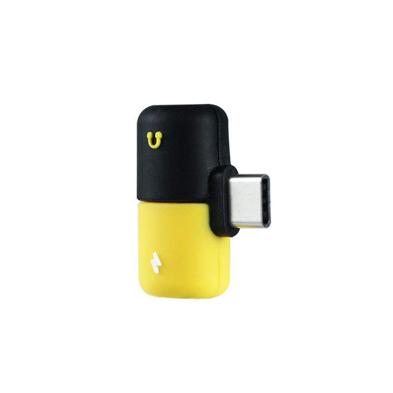 closeup view of type-C adapter with black and yellow color design, engraved lightning and headphones icon on it